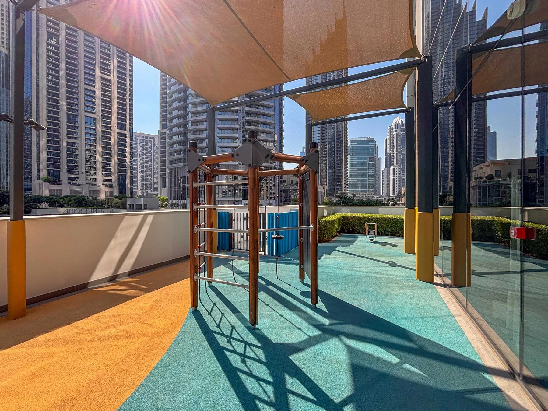 Una zona de ejercicio en la azotea, con equipos y edificios de la ciudad al fondo.