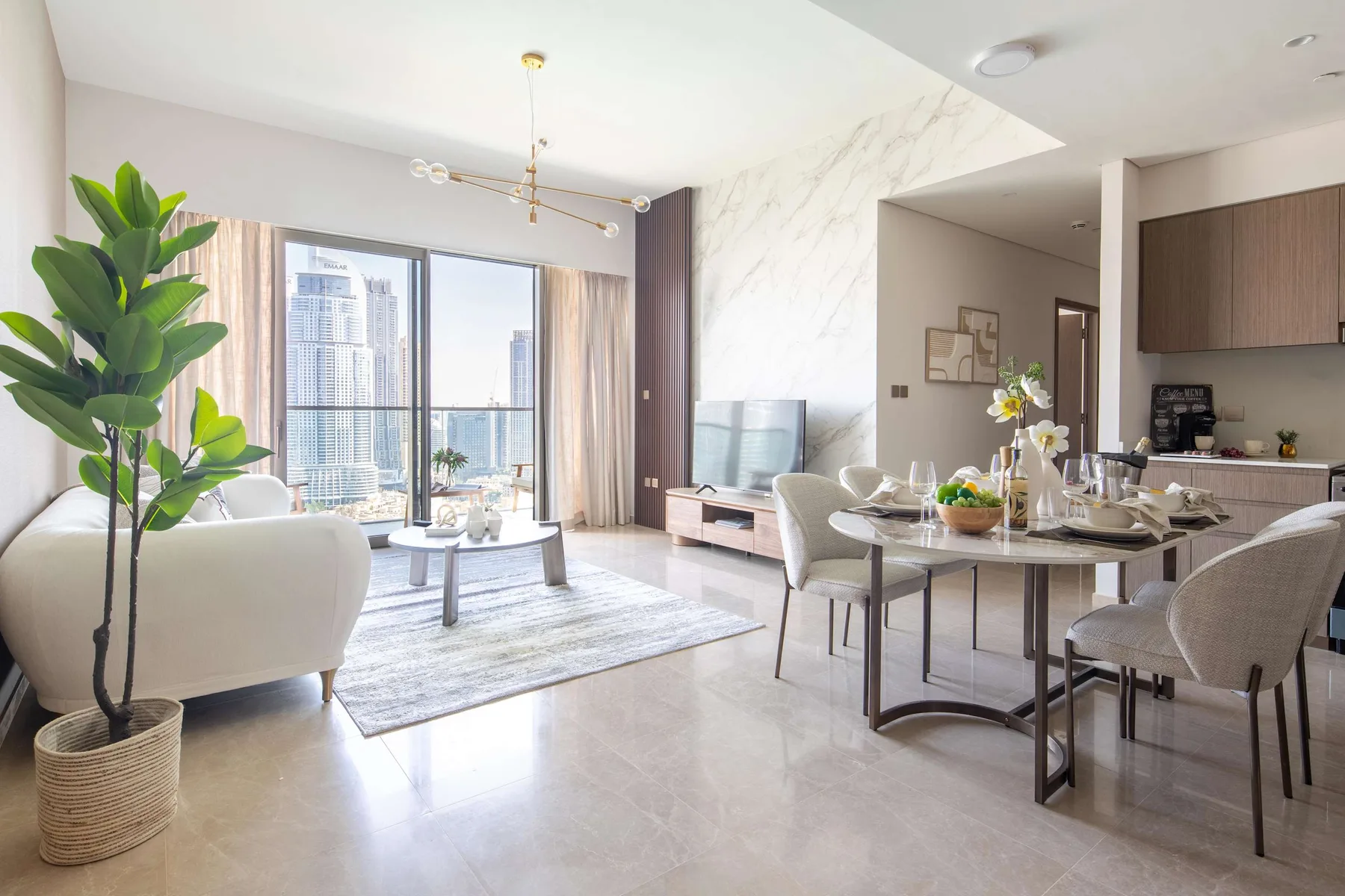 A bright open-plan living and dining area with large windows and a dining table.
