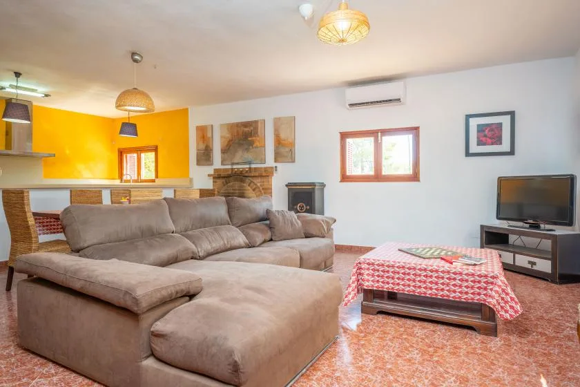 Una sala de estar con asientos seccionales, un televisor y una mesa de centro.