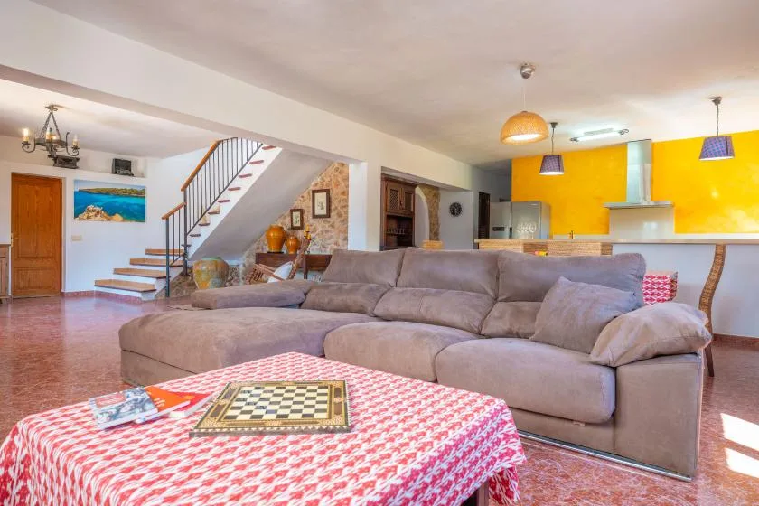 Una sala de estar con un sofá seccional grande y una mesa en primer plano.