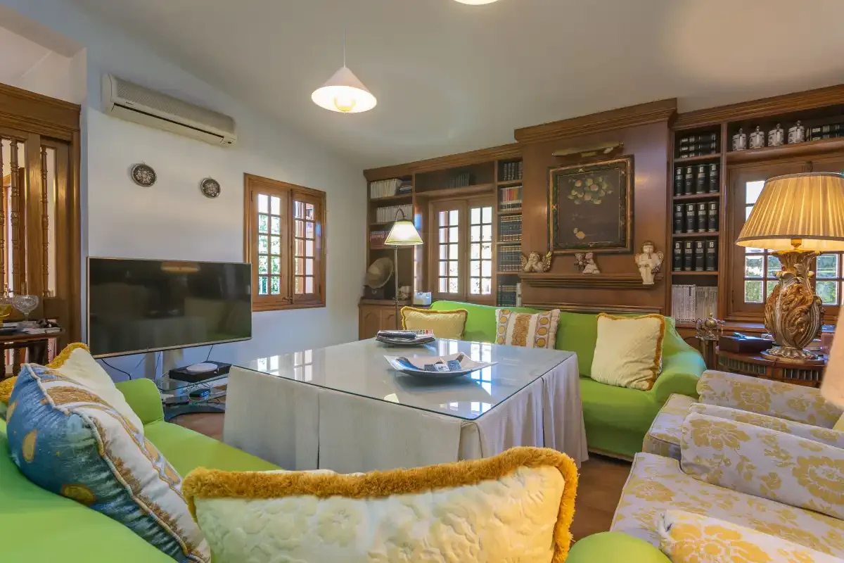A living room with green seating arranged around a dining table.