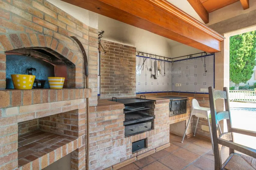 An outdoor cooking area with a brick oven and built-in grill.