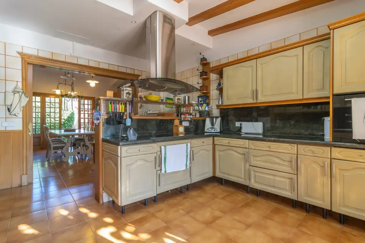 A spacious kitchen with light cabinetry and a central cooking area.