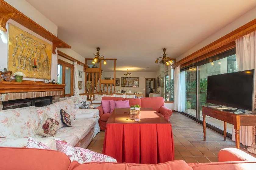 A living room with seating, a coffee table, and large windows.