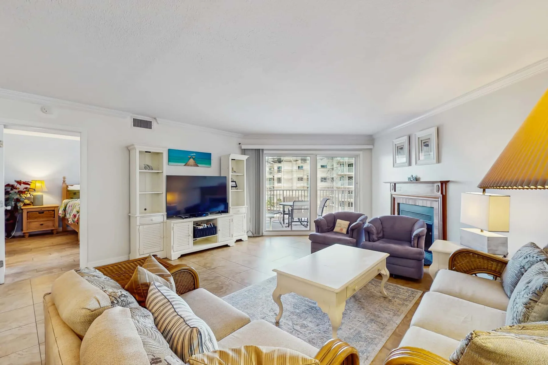 A bright living room with seating arranged around a white coffee table.