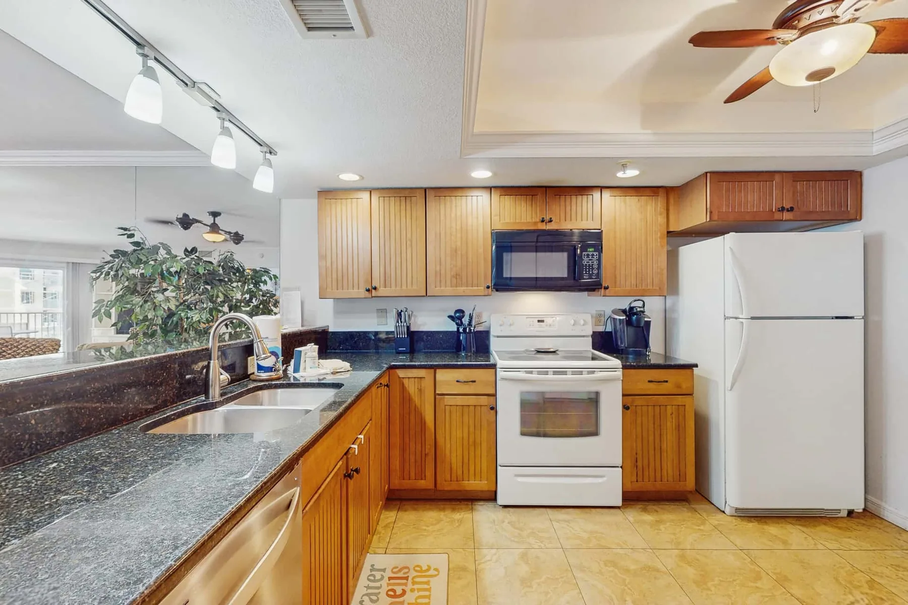 A kitchen with wooden cabinets, a countertop, and a white refrigerator.