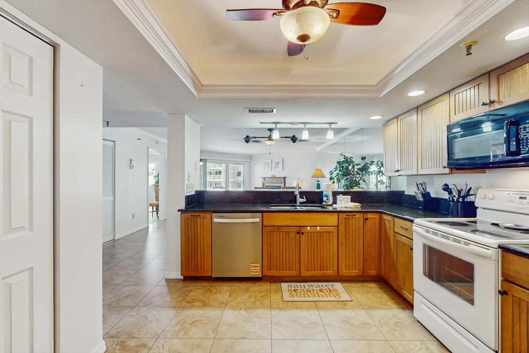 A kitchen with wooden cabinets, a countertop, and a white stove.