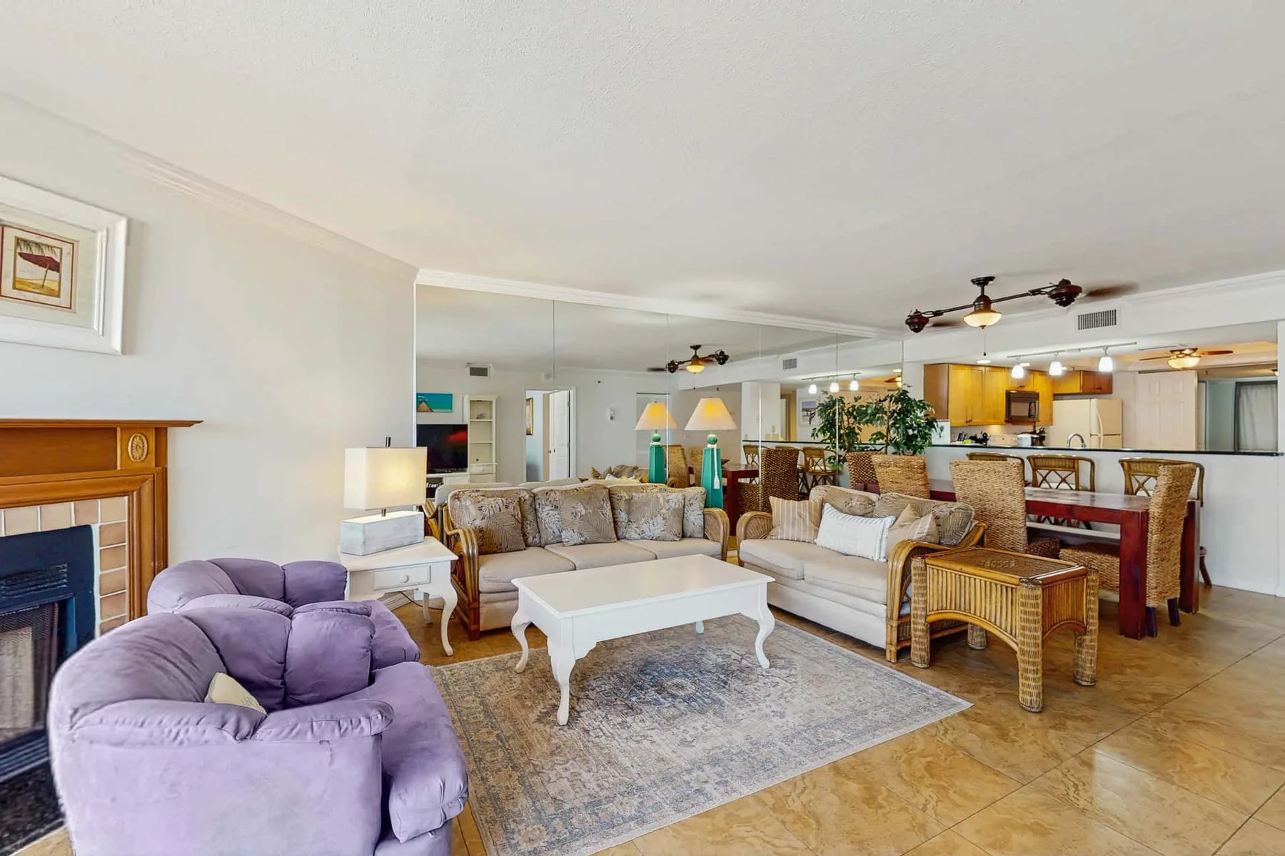 A spacious living area with seating, a coffee table, and an open kitchen.