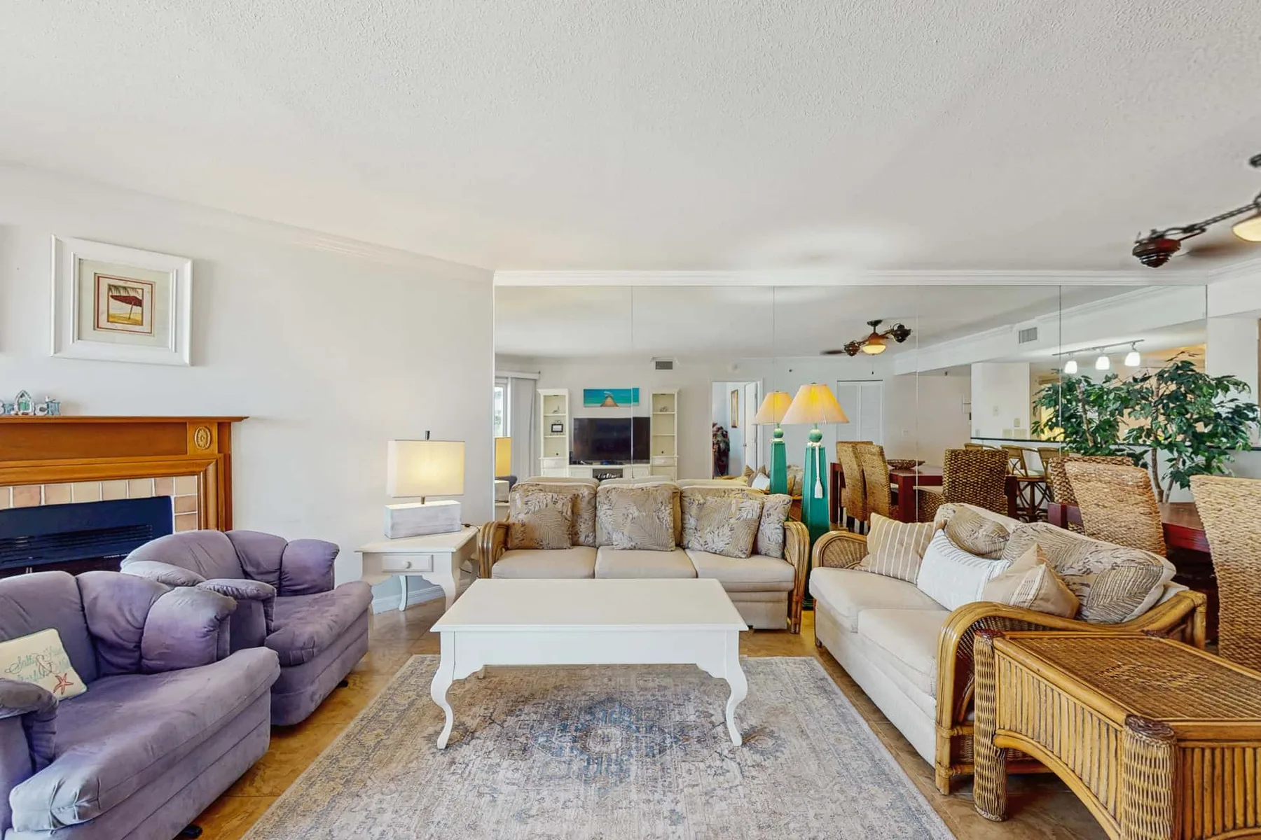 A bright living room with several seating areas arranged around a coffee table.