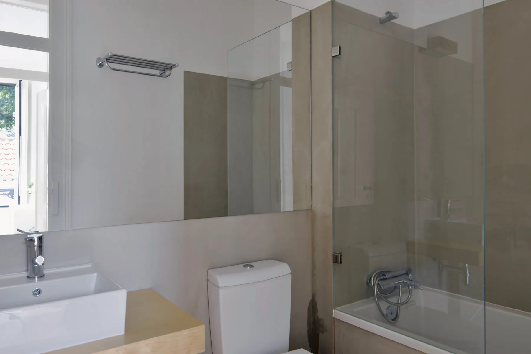 A bathroom with a sink, toilet, and glass-enclosed shower.
