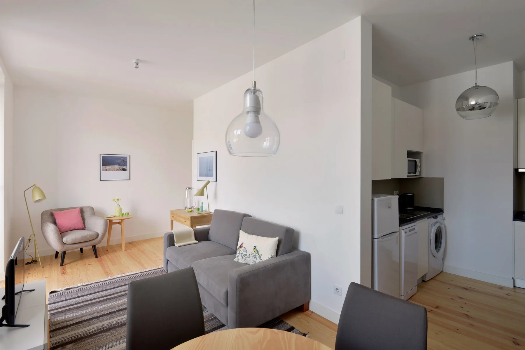An open-plan living room with seating and a kitchen area.