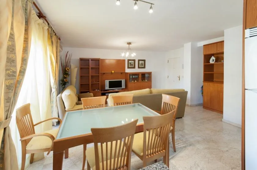 A living and dining area with a table, chairs, and seating.