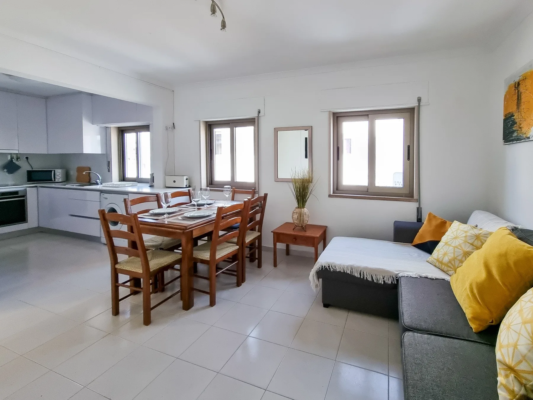 Una luminosa sala de estar y comedor diáfana, con cocina y asientos seccionales.