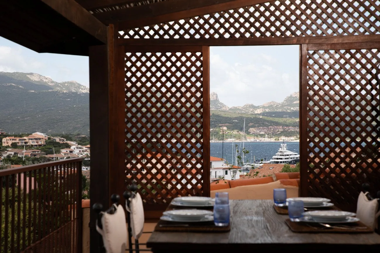 A covered dining area overlooks the harbor and surrounding mountains.