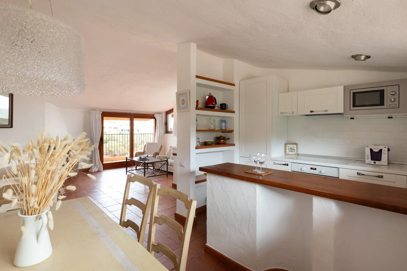 An open-plan kitchen and dining area with a wooden counter and table.
