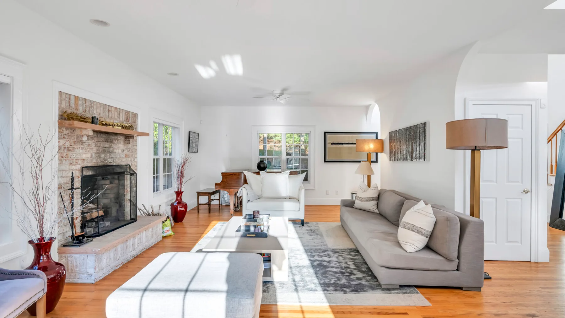 Una sala luminosa con asientos dispuestos alrededor de una chimenea y una mesa de centro.