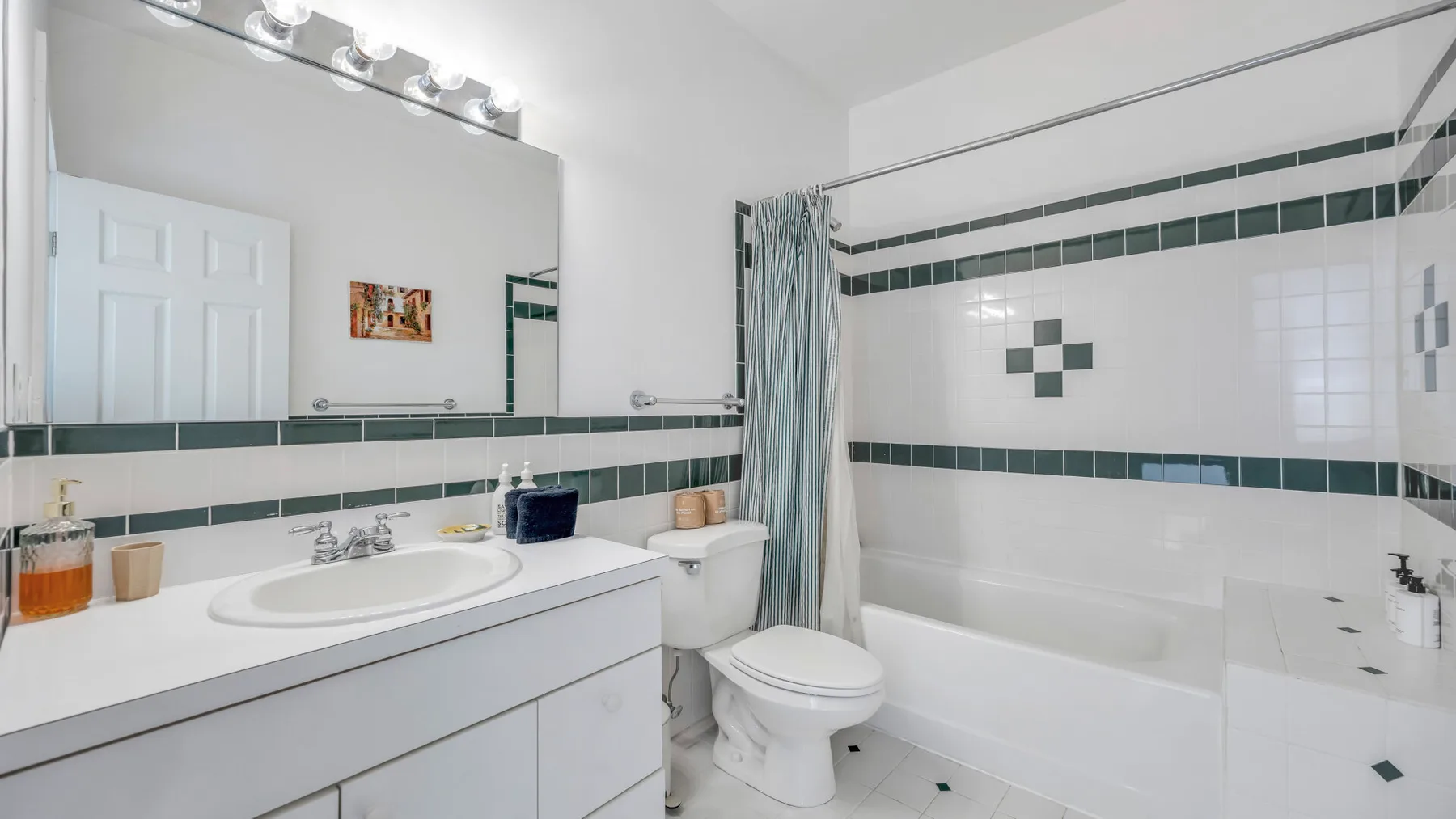Un baño con lavabo, inodoro y bañera detrás de una cortina de ducha.