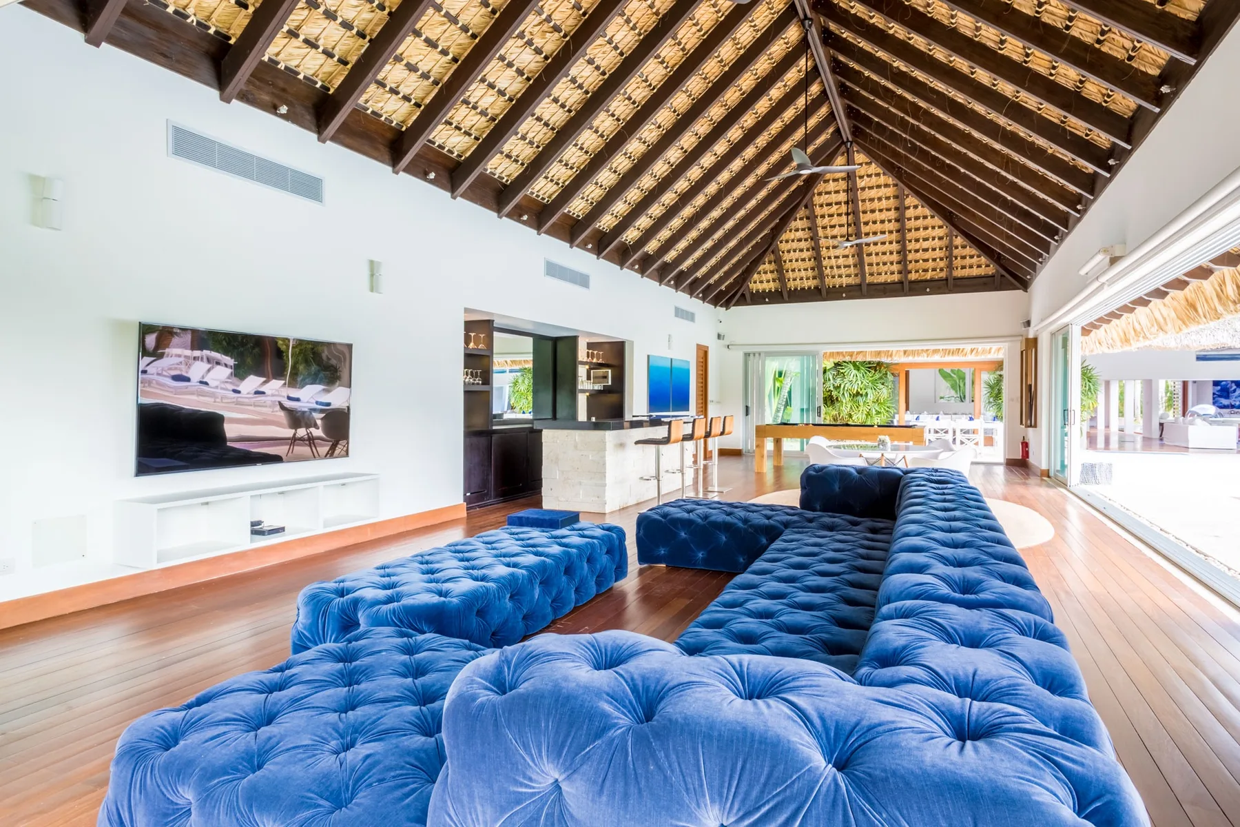 Una sala luminosa con asientos azules y un alto techo de vigas expuestas.