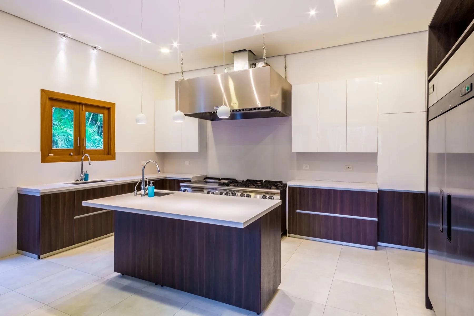 Una cocina moderna con una isla central y armarios superiores blancos.