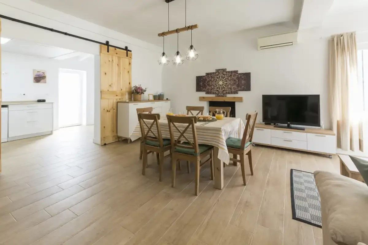 An open-plan living and dining area with a table, seating, and television.