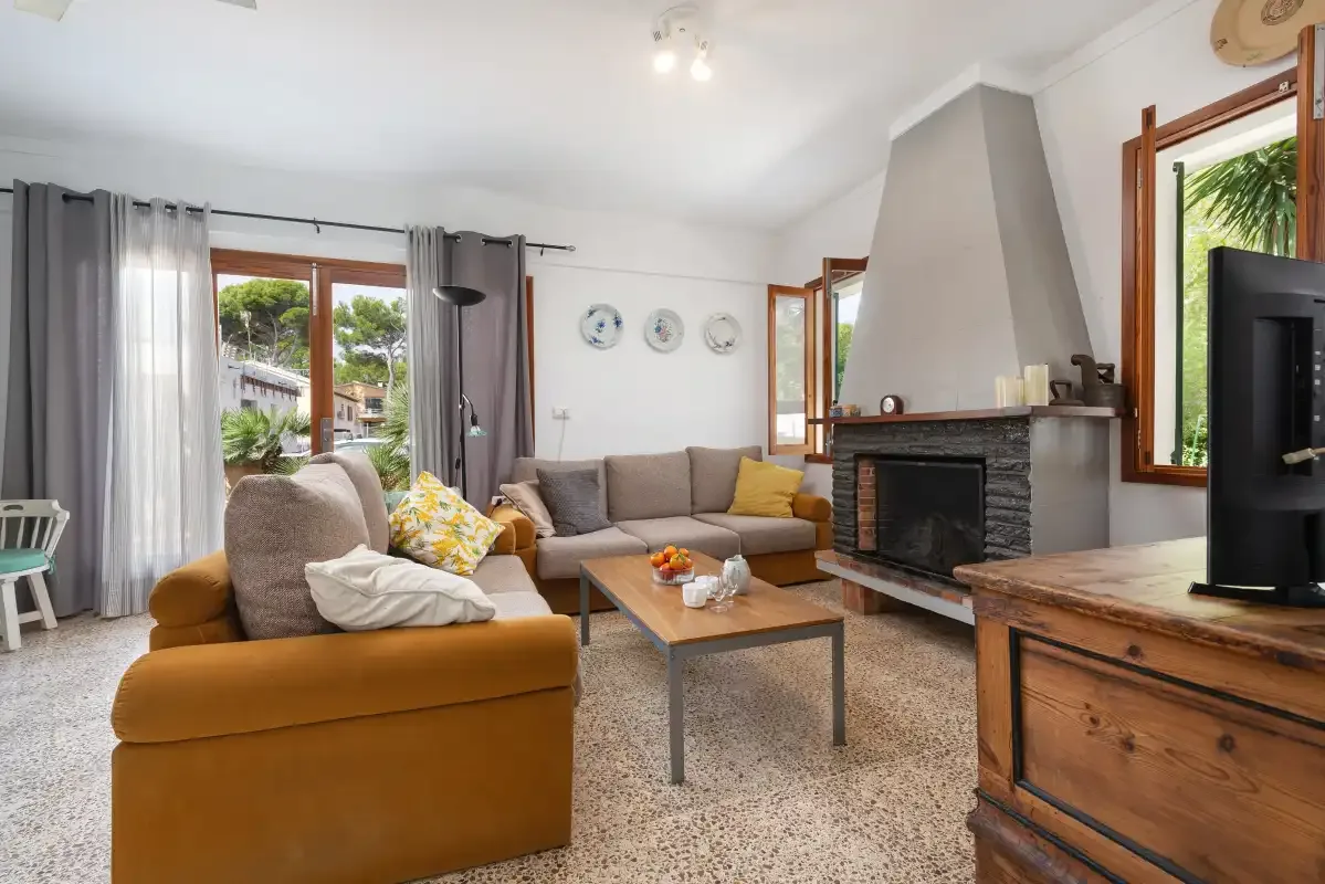 Una sala de estar con asientos alrededor de una mesa de centro y una chimenea.