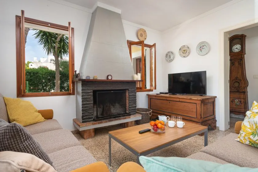 Una sala de estar con chimenea, televisor y asientos alrededor de una mesa de centro.