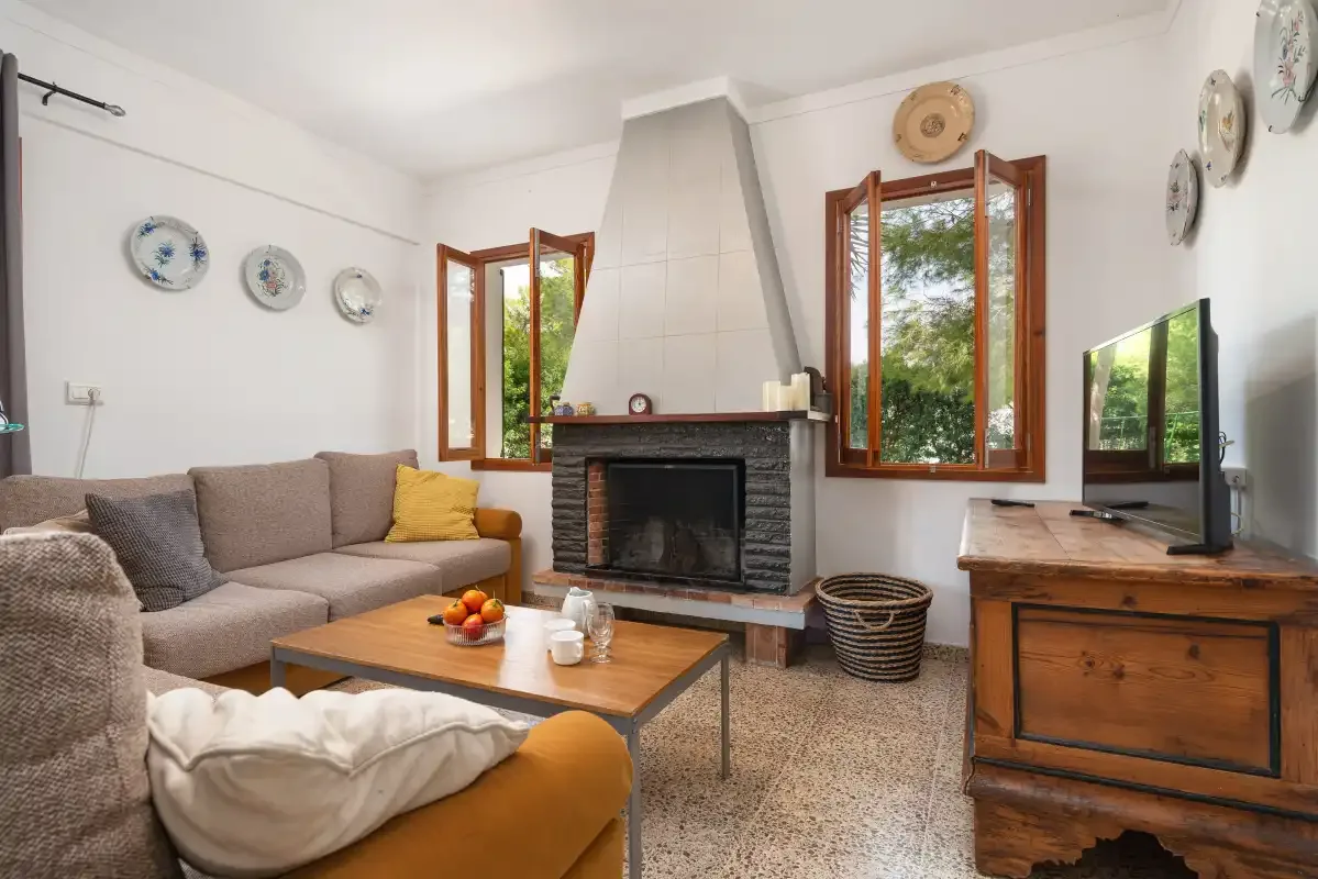 Una sala de estar con asientos alrededor de una chimenea y una mesa de centro de madera.