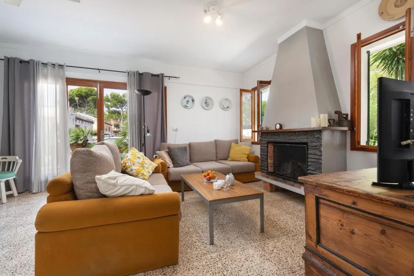 Una sala de estar con asientos alrededor de una mesa de centro y una chimenea.
