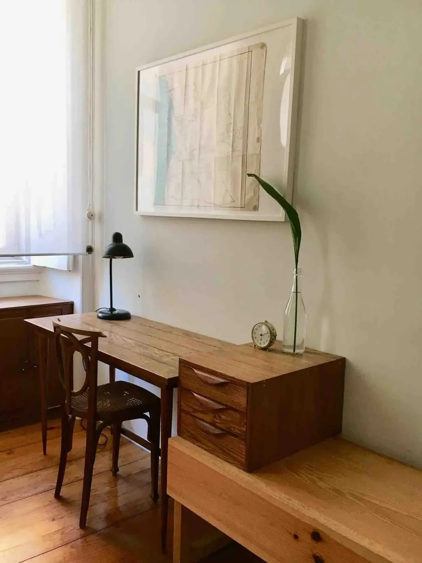 Comedor con una mesa de madera, sillas y un aparador junto a una ventana.