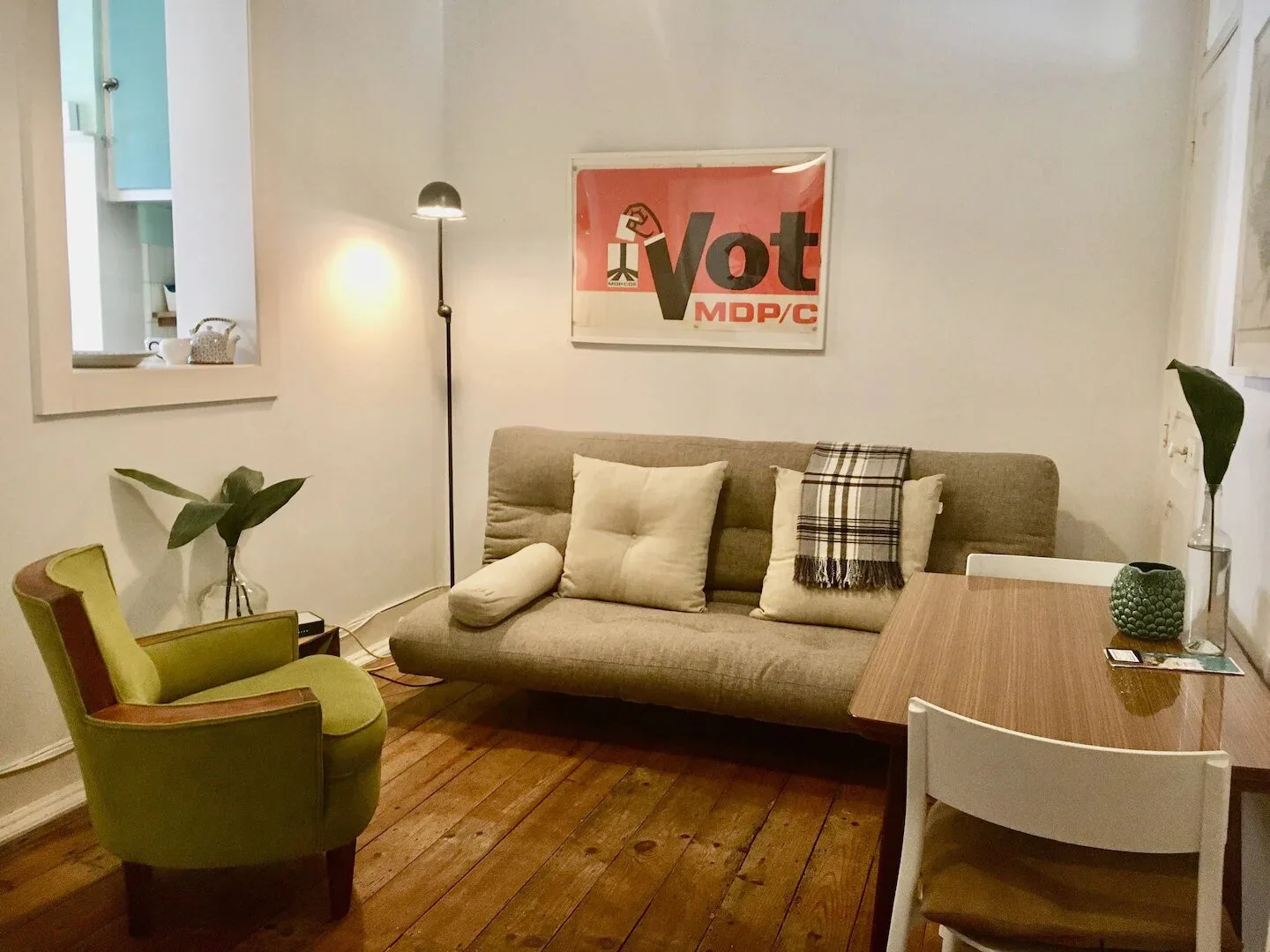 Una sala de estar con un sofá, asientos verdes y una mesa de centro de madera.