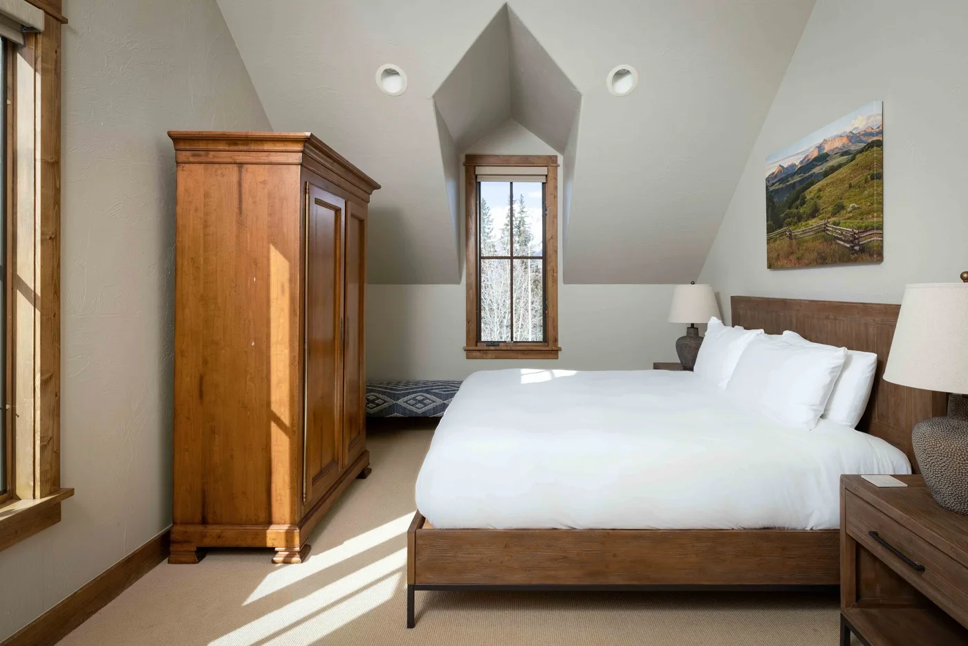 A bright bedroom with a wooden bed, white bedding, and a large wardrobe.