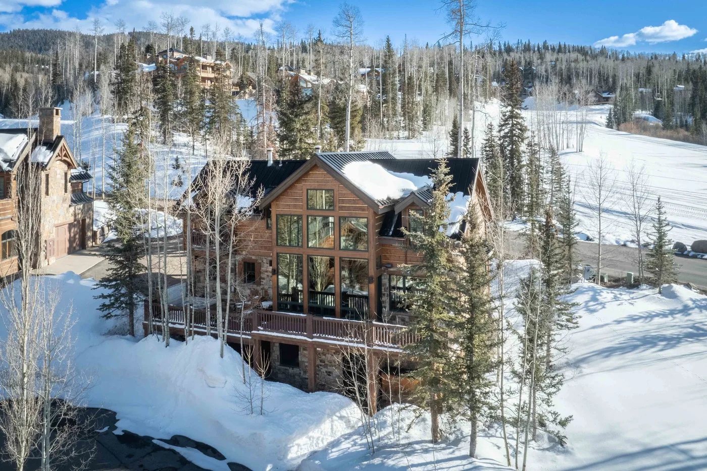 A wooden cabin stands among snow-covered trees in a winter landscape.