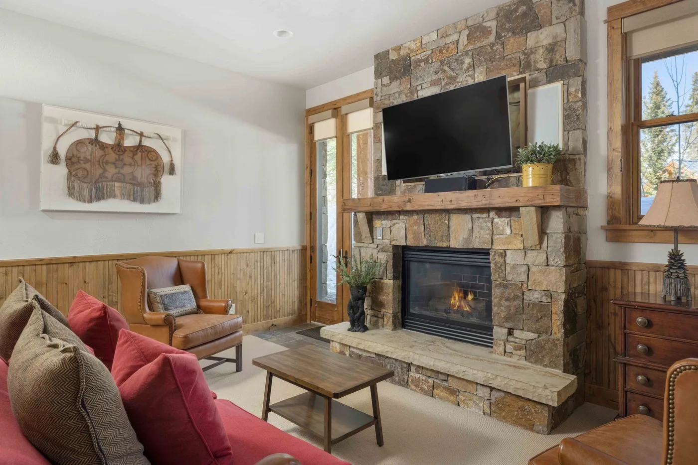 A living room with a stone fireplace, television, and seating.