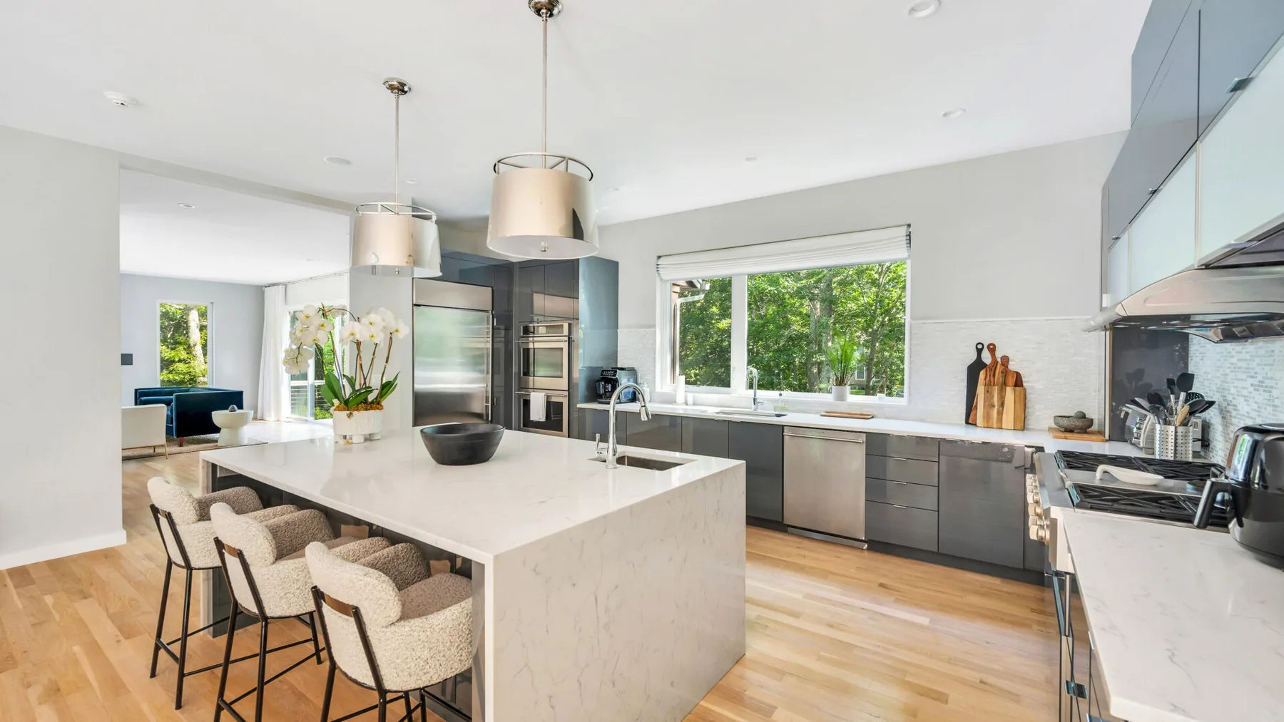 A bright kitchen with a large island and dark cabinetry.