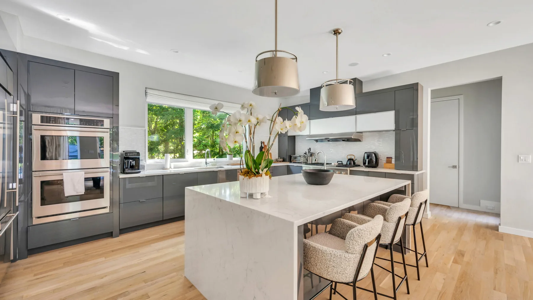 A modern kitchen with dark cabinetry, a large island, and seating.