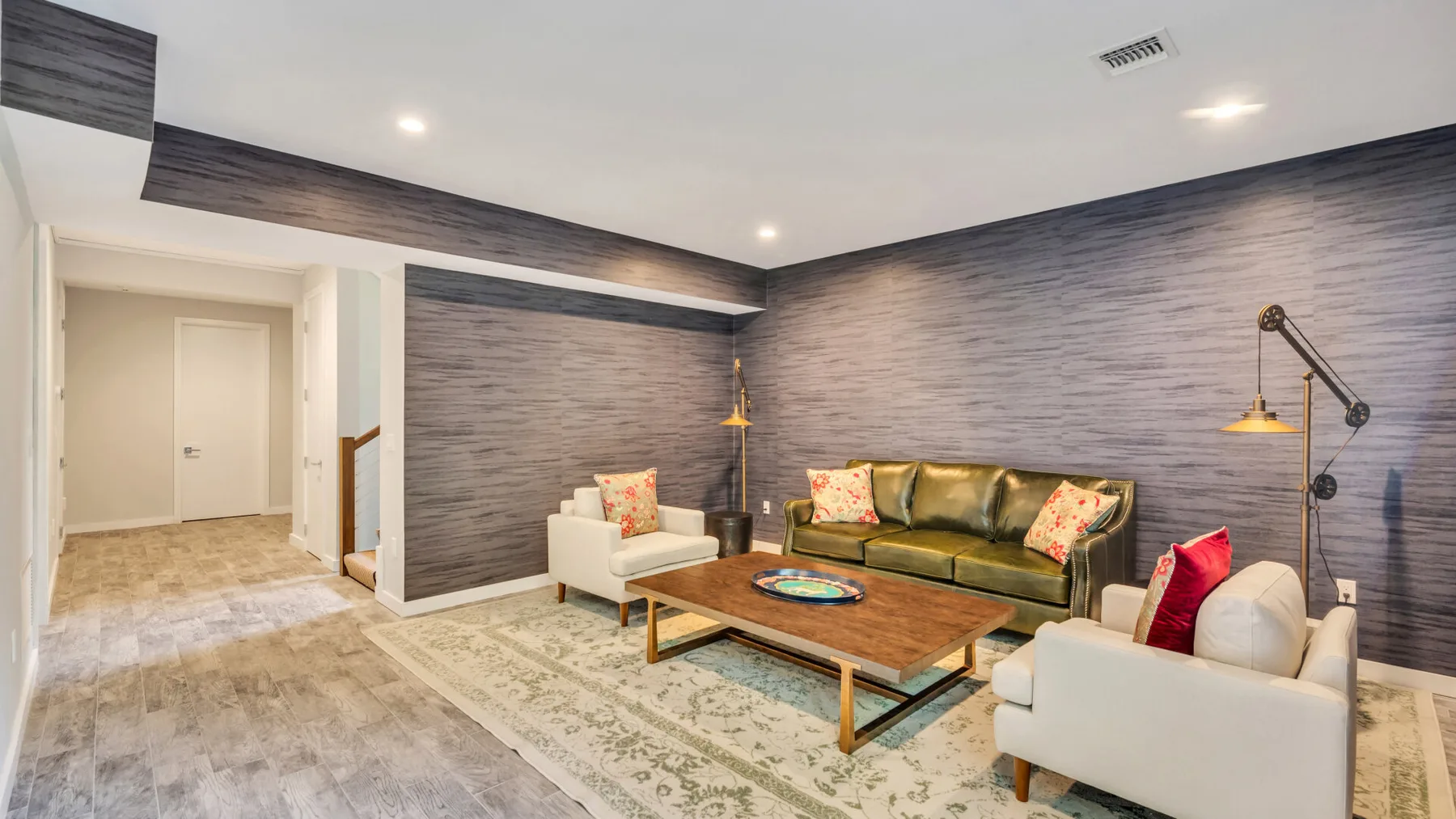 A living room with a sofa, armchairs, and a wooden coffee table.