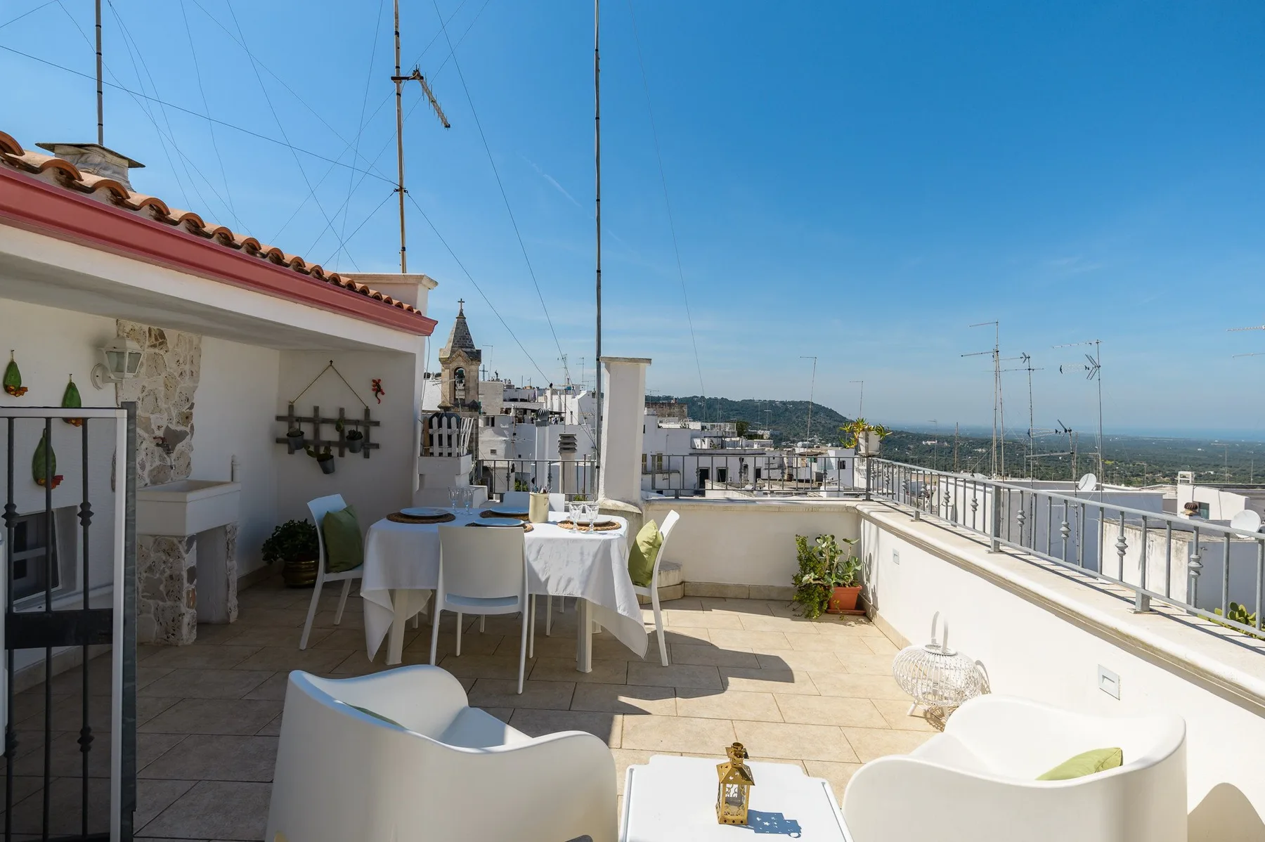 A rooftop terrace with outdoor seating and views across nearby buildings.