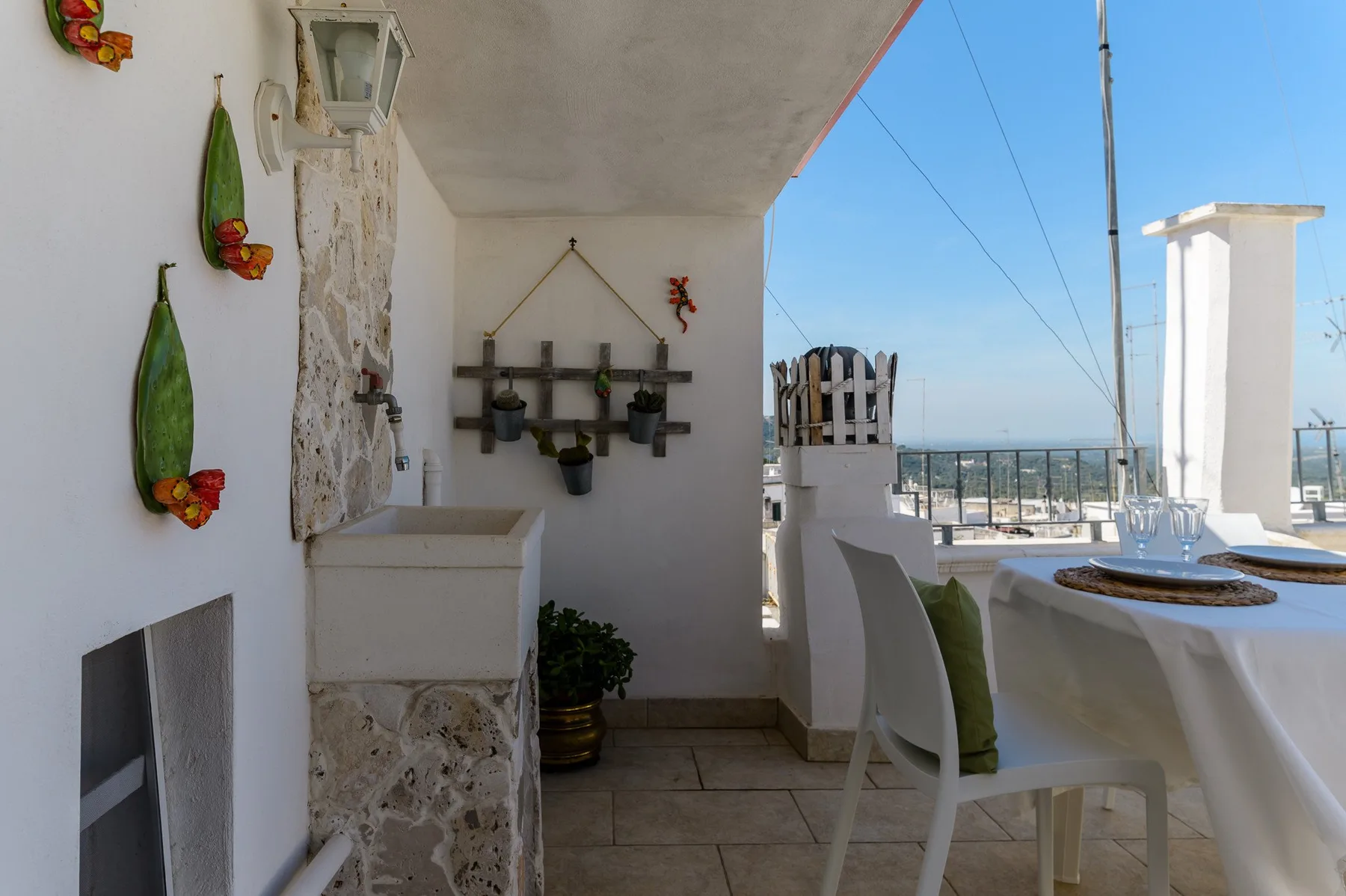 A covered outdoor dining area with a set table overlooking the sea.