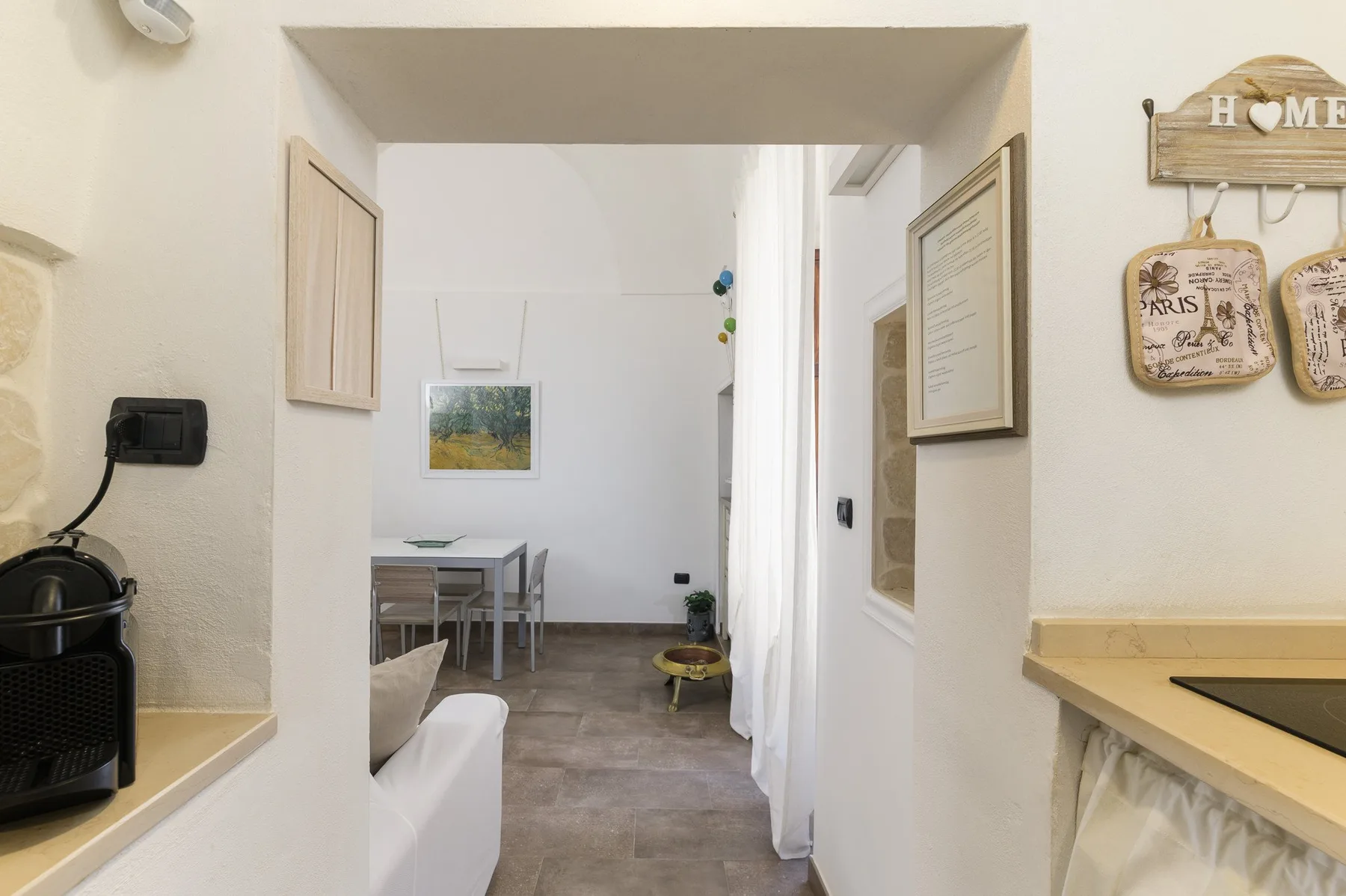 A bright interior passage opens into a small dining area, with seating along the side.