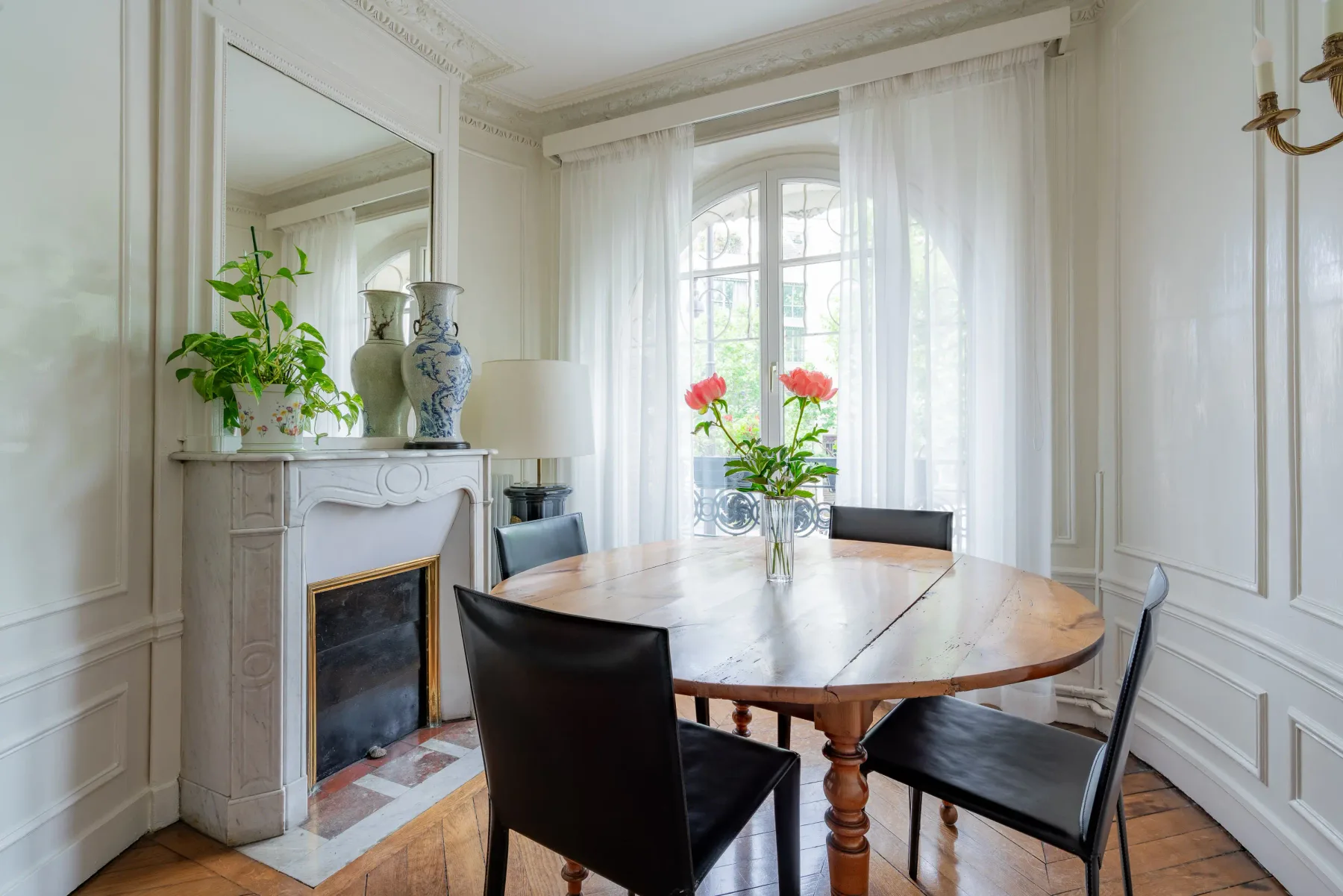Un comedor luminoso con una mesa de madera y sillas junto a una chimenea.