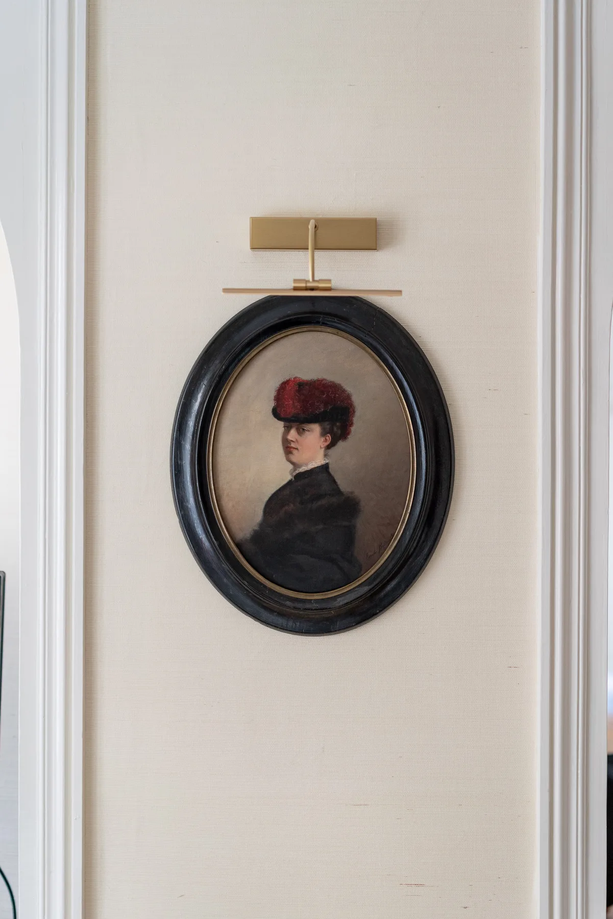 Un retrato enmarcado cuelga de una pared clara.