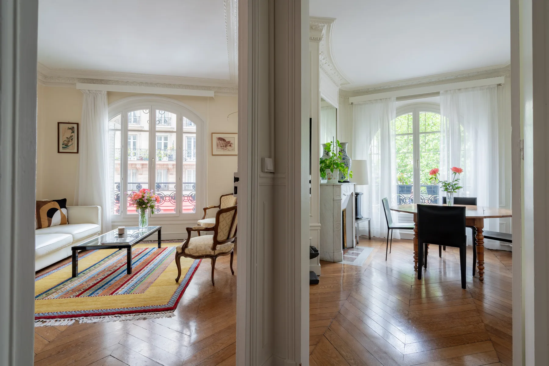 Una sala luminosa con una alfombra colorida y asientos junto a ventanas altas.