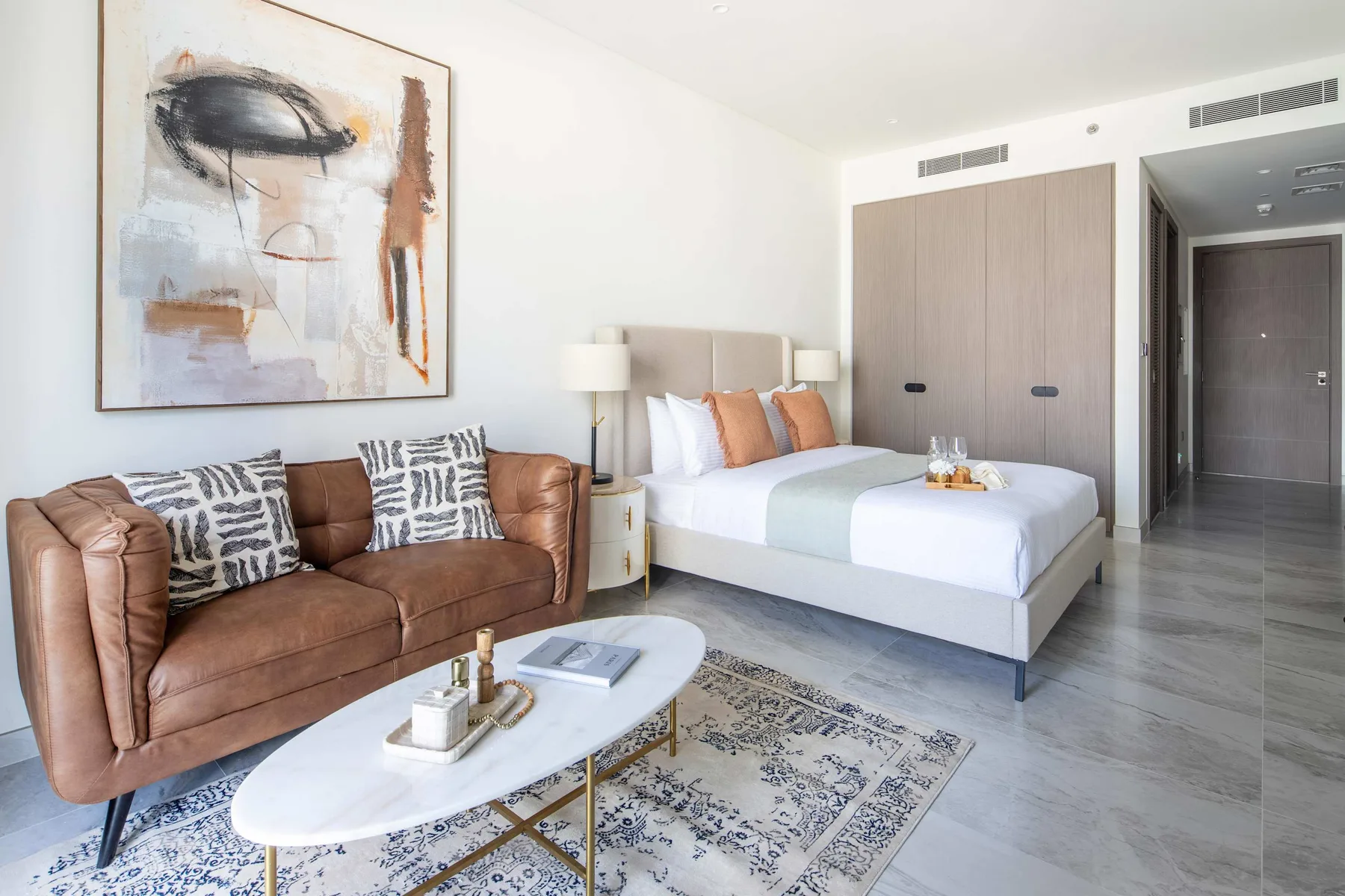 Un dormitorio con una cama, asientos y una mesa de centro.