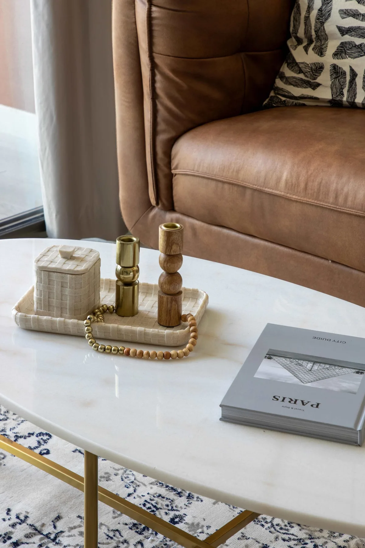 A living room seating area with a brown leather sofa beside a white coffee table.