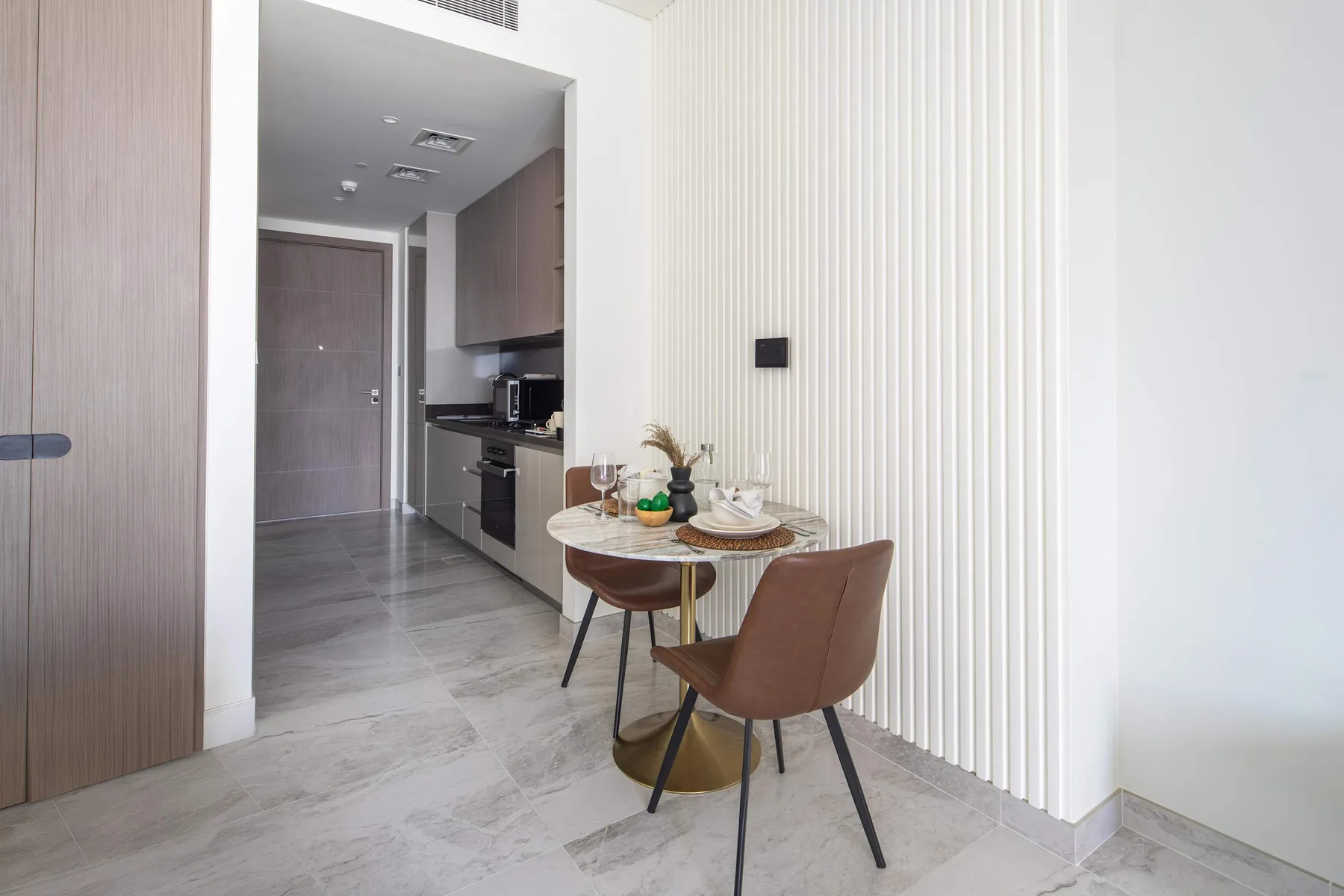 Un comedor con una mesa pequeña y sillas junto a una cocina.