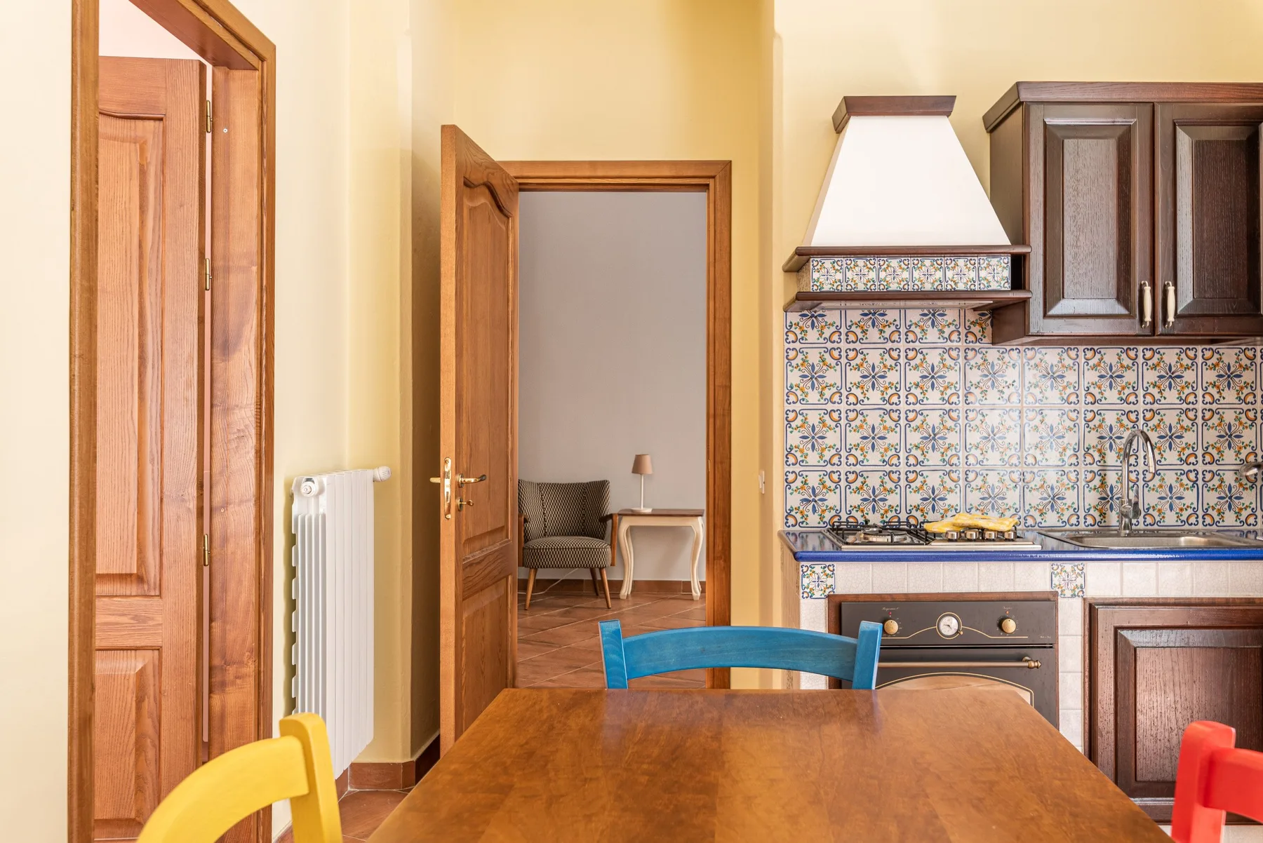Una cocina y comedor con una mesa de madera y un salpicadero de azulejos estampados.