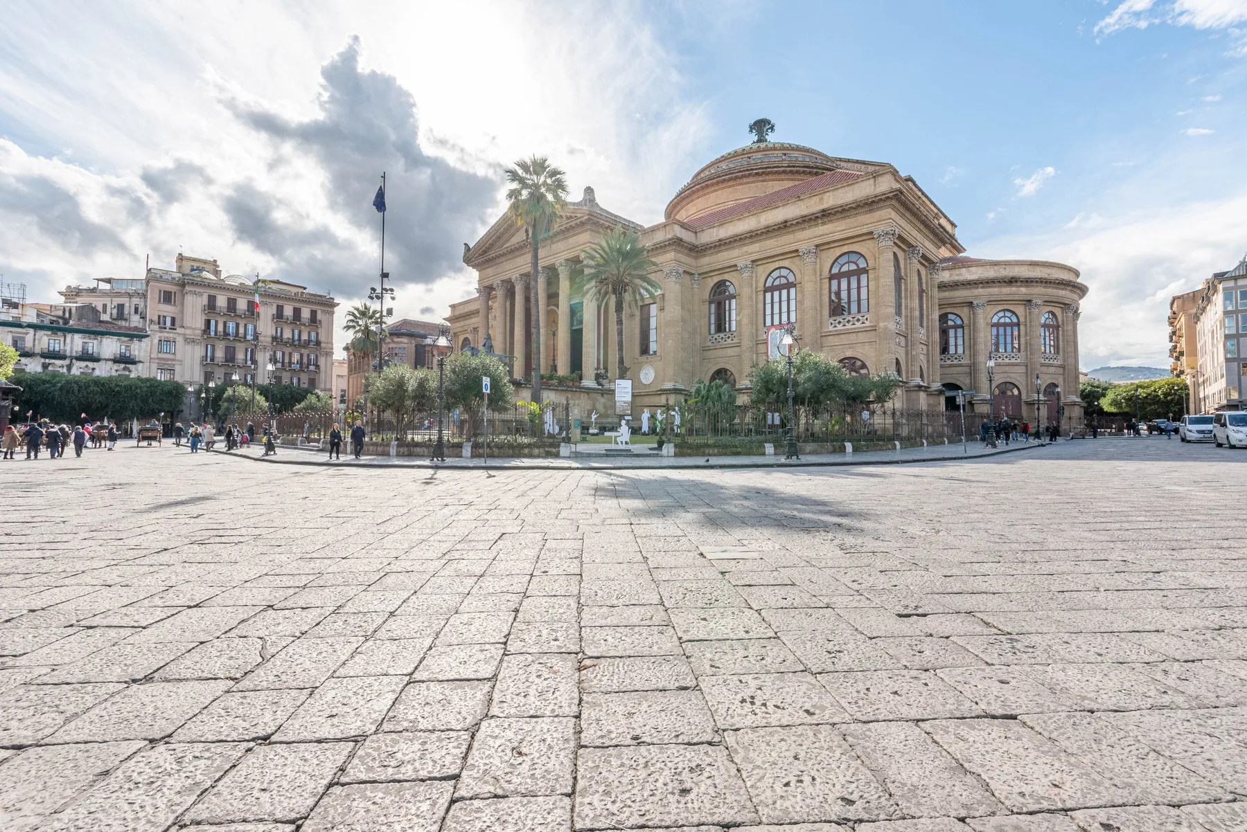 A large historic building stands beside an open paved square.