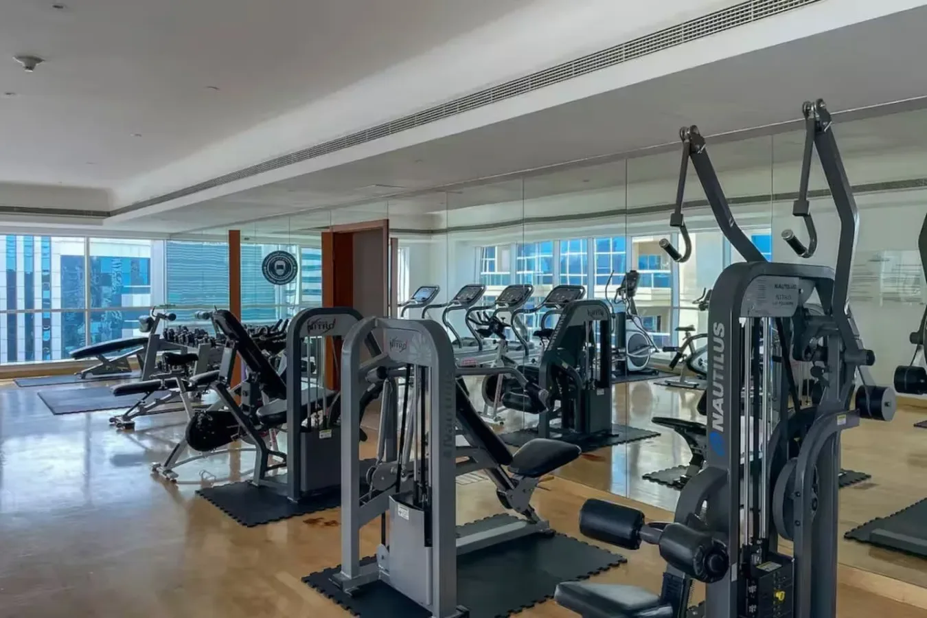 Un gimnasio con máquinas de pesas y equipo de ejercicio distribuido por la sala.