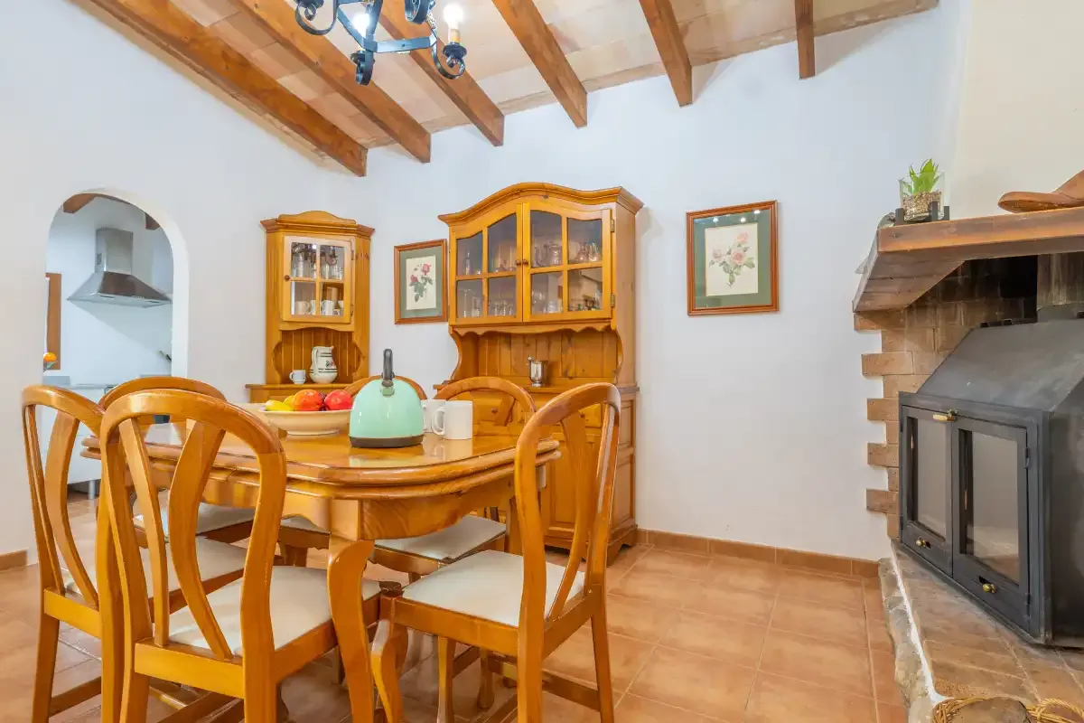 A dining area with wooden seating, cabinets, and a fireplace.
