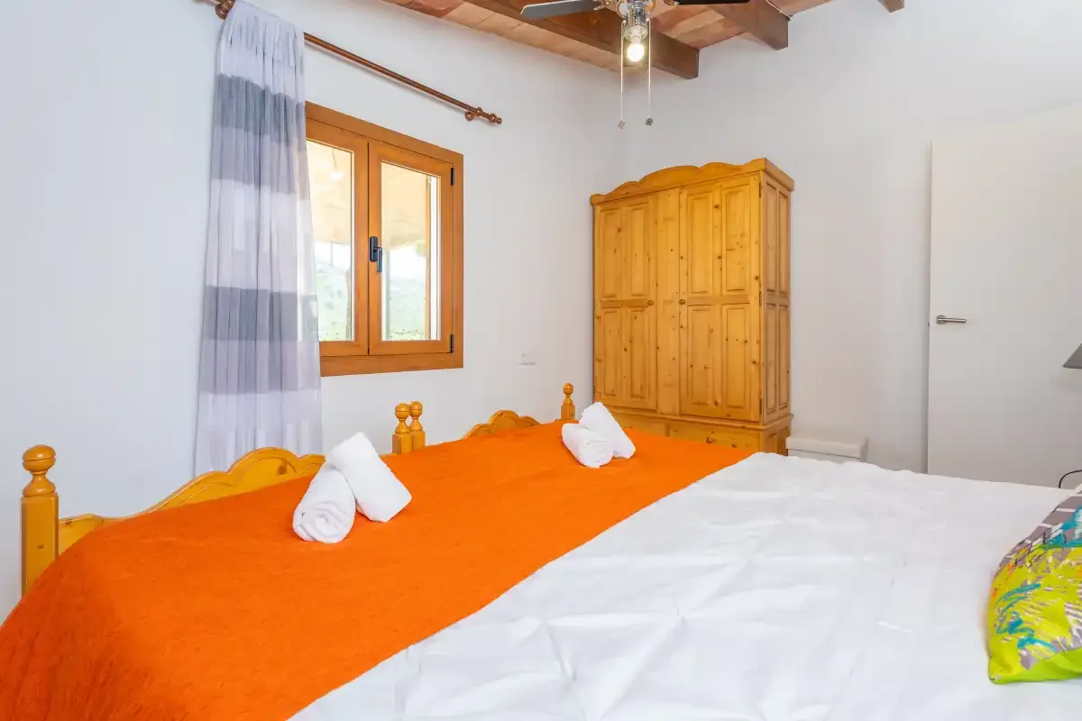 A bedroom with two beds and a wooden wardrobe.